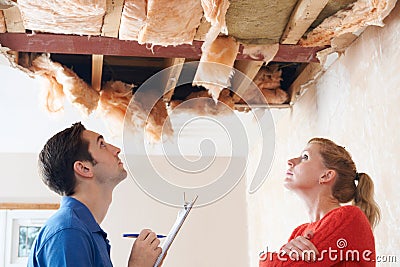 Builder And Client Inspecting Roof Damage Stock Photo