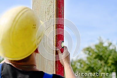 Builder ensuring that a beam is vertical Stock Photo