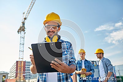 Builder in hardhat with clipboard at construction Stock Photo