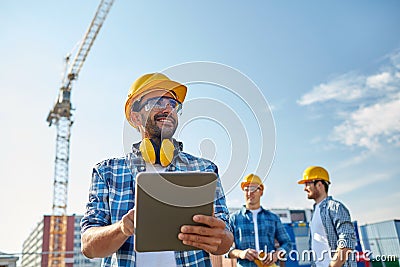 Builder in hardhat with tablet pc at construction Stock Photo