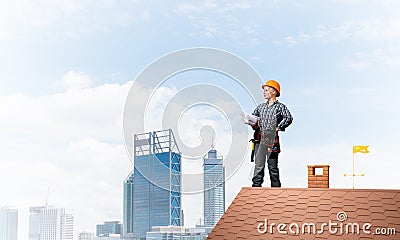 Builder in hardhat with technical blueprints Stock Photo