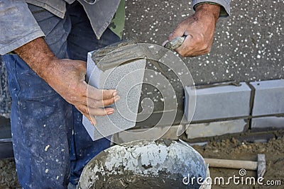 Builder holding a brick and with masonry trowel spreading and sh Stock Photo