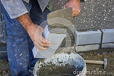 Builder holding a brick and with masonry trowel spreading and sh Stock Photo