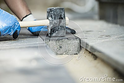 Builder laying a paving stone or brick Stock Photo