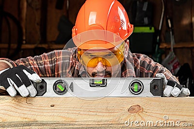 Builder man looks at the construction level checks the horizontal surface, male hands with a level close-up. Construction work, Stock Photo