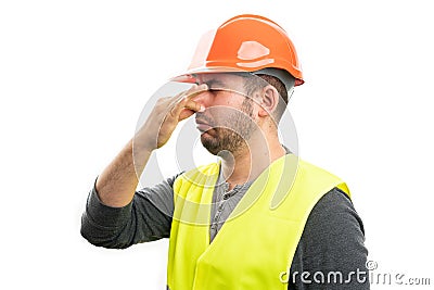 Builder man making grossed expression holding nose as bad smell Stock Photo