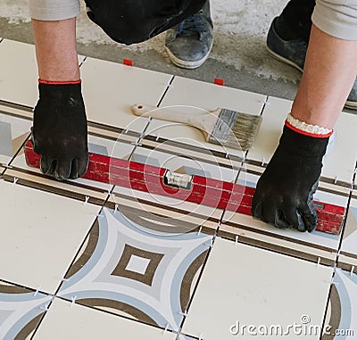 The builder-mason controls the level of the horizontal tile with Stock Photo