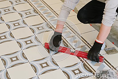 The builder-mason controls the level of the horizontal tile with Stock Photo