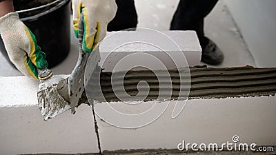 Builder-mason working with aerated concrete blocks. Building walls, placing bricks on a construction site, engineering Stock Photo