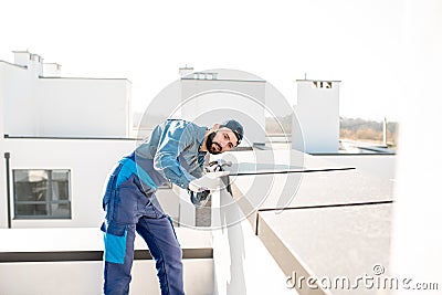 Builder mounting metal cover on the parapet of a new building Stock Photo
