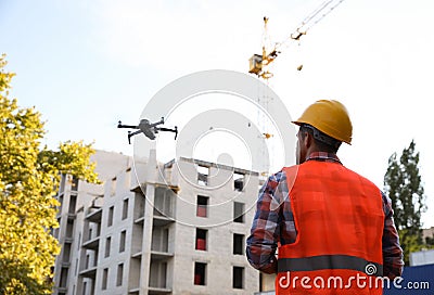 Builder operating drone with remote control at construction site. Aerial photography Stock Photo