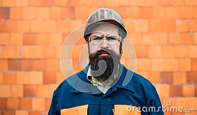 Builder. Portrait mechanical worker. Bearded man in suit with construction helmet. Portrait of handsome engineer Stock Photo