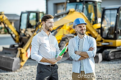 Builder with a sales consultant at the shop with heavy machinery Stock Photo