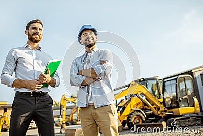 Builder with a sales consultant at the shop with heavy machinery Stock Photo