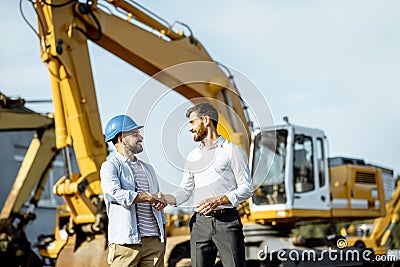 Builder with a sales consultant at the shop with heavy machinery Stock Photo