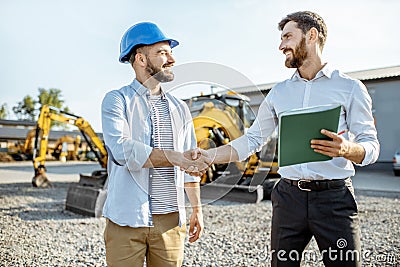 Builder with a sales consultant at the shop with heavy machinery Stock Photo