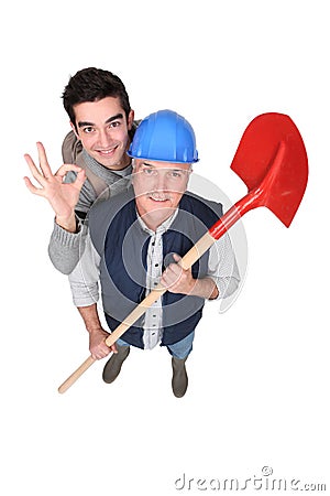 Builder stood with young apprentice Stock Photo