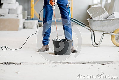 Builder mixing plaster at the construction site Stock Photo