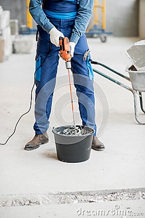 Builder mixing plaster at the construction site Stock Photo