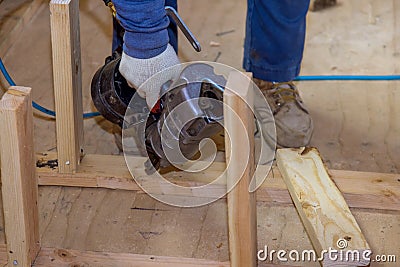 Builder uses an air hammer to nail wooden beams for support of a building Stock Photo