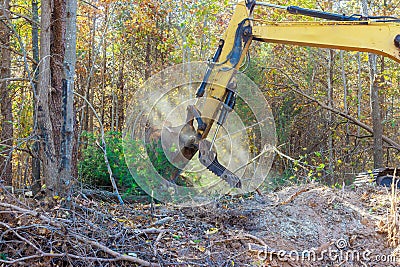 A builder uses tractor to uproot trees in forest in preparation for construction of house Stock Photo