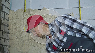 Builder in Work Wear Putting Plaster on Aerated Concrete Block Wall