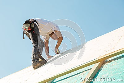 Builder at work with wooden roof construction. Stock Photo