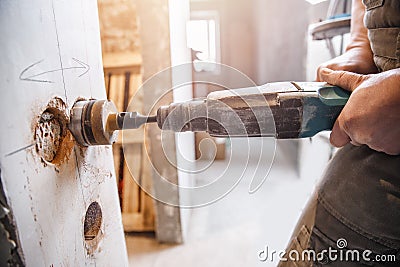 Builder worker pneumatic hammer drills hole in concrete brick wall with diamond crown for electric cable, socket, switch Stock Photo