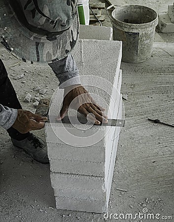 builder worker use stainless steel ruler measure lightweight cement brick prepare for cut to install wall Stock Photo