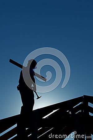 Builder working late on top of building Stock Photo