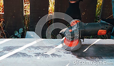 The builder works with an angle grinder. Wire cleaning brush. Cleaning metal embedded from rust and concrete Stock Photo