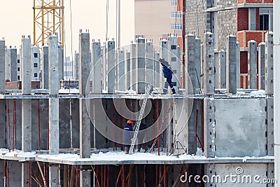 Builders in blue clothes on construction of building Stock Photo