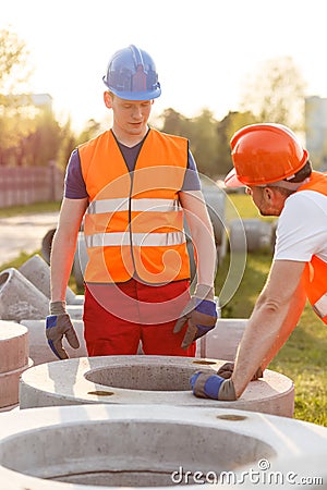 Builders and concrete pipes Stock Photo