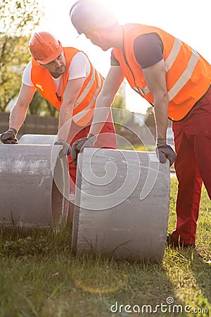 Builders and concrete pipes Stock Photo