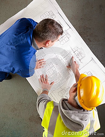 Builders examine blueprints Stock Photo