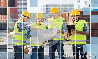 Builders in hardhats and vests with blueprint Stock Photo