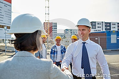 Builders making handshake on construction site Stock Photo