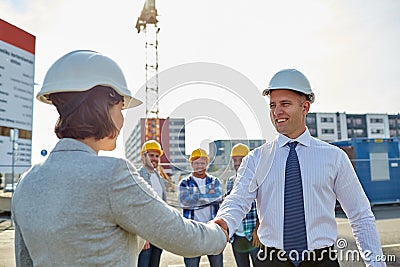 Builders making handshake on construction site Stock Photo