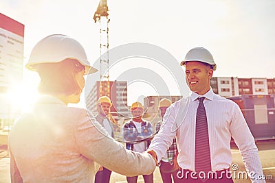 Builders making handshake on construction site Stock Photo