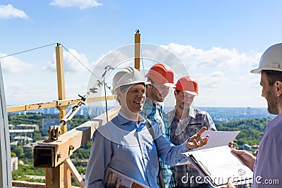 Builders Team Meeting With On Construction Site Discussing Project Plan With Architect Contractor Stock Photo