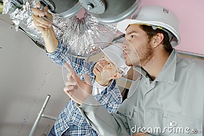 Builders working on ventilation system Stock Photo