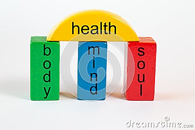 Building blocks in green, blue and red form a column portal with the following terms: body, mind, soul. The columns are connected Stock Photo