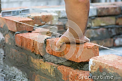 Building brick block wall on construction plant. Worker builds a brick wall in the house. Construction worker laying bricks on ext Stock Photo