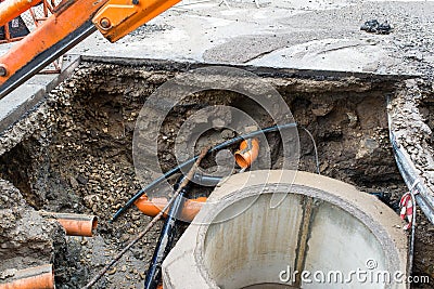 Building concrete sewage tank, flowing water trough orange pipes Stock Photo