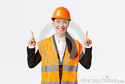 Building, construction and industrial concept. Satisfied successful female asian saleswoman showing clients object for Stock Photo