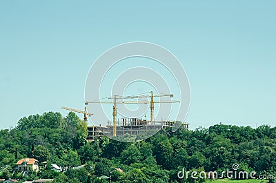 Building construction site with cranes and scaffold in the park for hotel or school college Stock Photo