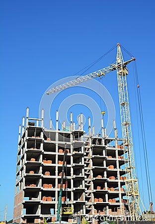 Building cranes on construction site with builders. Building high rise.Crane Construction. Tower Crane and Building Constructors Stock Photo