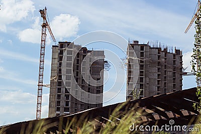 building cranes at front of a multi-storey uilding under construction, new house for many families Stock Photo