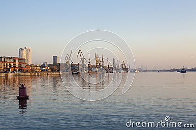 Building cranes on a river shore Stock Photo