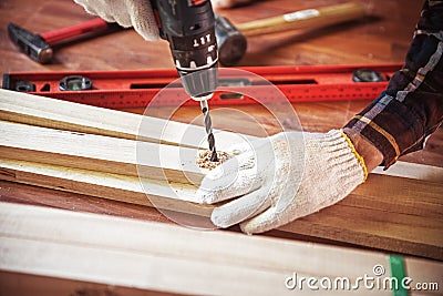 Building DIY with drilling machine. Professional carpenter working with wood and building tools in house for renovate. Stock Photo
